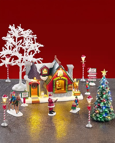 Scène de Noël Lemax avec maison illuminée, Père Noël et arbre décoré.